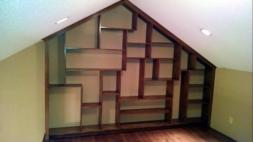 Custom built-in bookshelves shaped to fit an attic gable wall