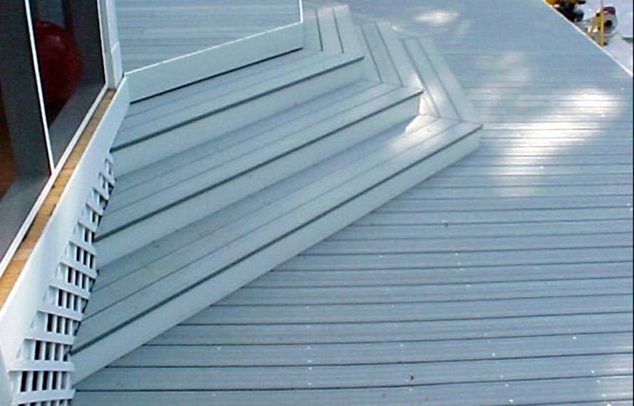 Angled composite deck steps beside a screened porch