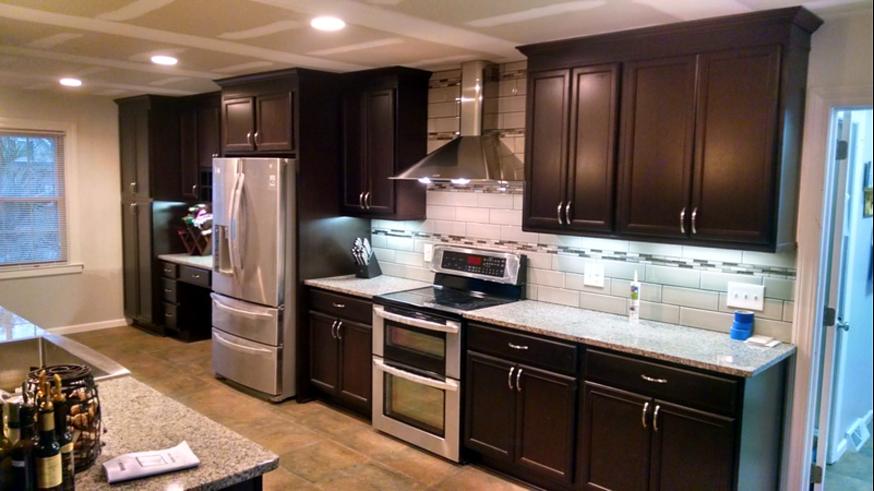 Finished kitchen with dark wood cabinets, subway tile backsplash and stainless appliances