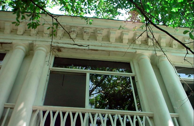 Two-story porch with white columns and a decorative railing