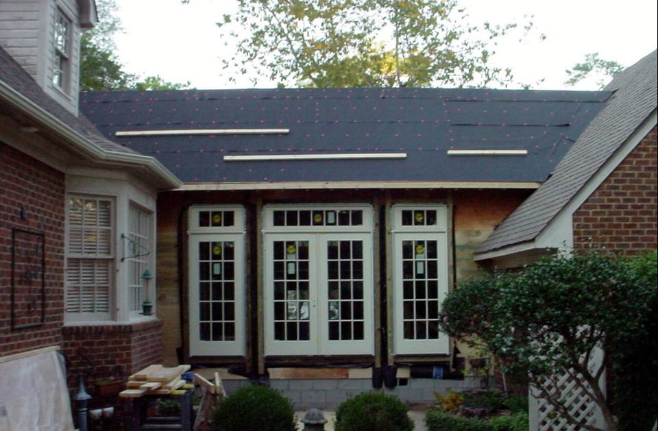 Sunroom addition under construction with a wall of French doors