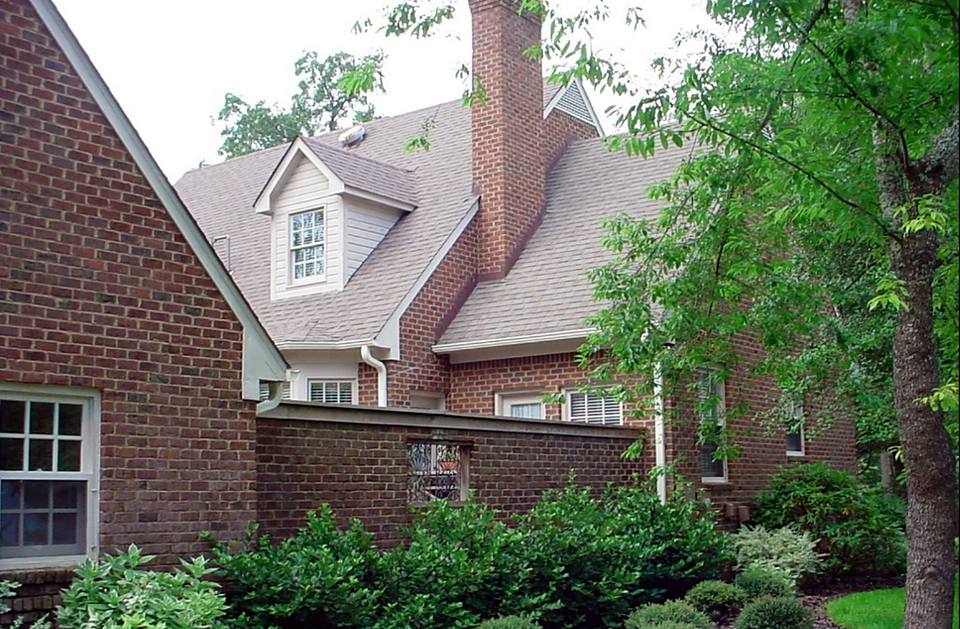 Brick home with a dormer and landscaped garden
